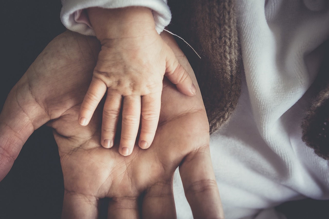 dłoń dziecka na dłoni dorosłego