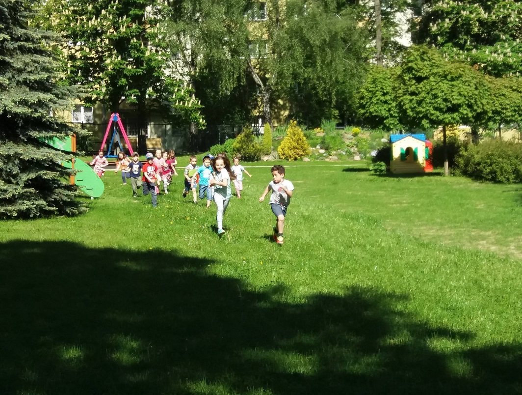 Dzieci biegnące przez ogród