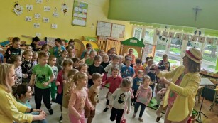 Grupa roześmianych dzieci tańczy naśladując piosenkarkę.